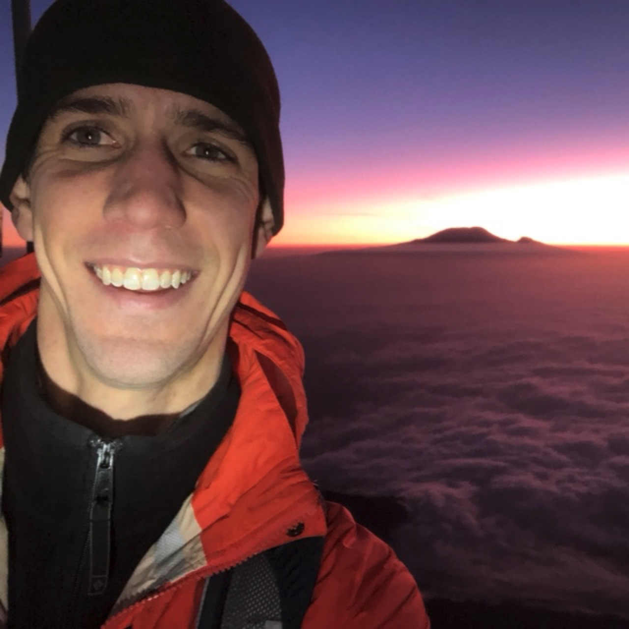 The author enjoying sunrise over Kilimanjaro from the summit of Mount Meru